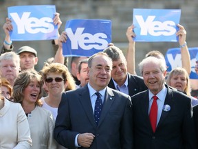 Scotland's First Minister Alex Salmond, centre, poses for photographs with former deputy leader of the Scottish National Party, Jim Sillars, as they campaign in Edinburgh, Scotland.  (Reuters file photo)