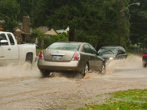 Flooding on Springbank Dr. west of Wonderland Rd., slowed traffic during the worst of the downbursts in London on Wednesday. (MIKE HENSEN, The London Free Press)