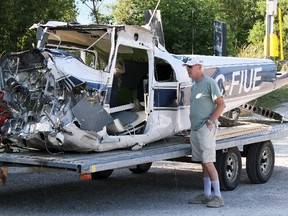 James Masters/QMI Agency
A bystander examines the damaged fuselage of a Cessna 182 float plane on a trailer at Big Bay east of Wiarton on July 6, 2013. The fuselage and plane parts belonged to a float plane that crashed off Griffith Island, killing three Sudbury men.
