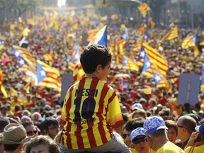 A boy wearing Lionel Messi's jersey sits on the shoulders of a relative as Catalans holding independentist flags (Estelada) gather on Gran Via de les Corts Catalanes during celebrations of Catalonia National Day (Diada) in Barcelona on September 11, 2014. (AFP PHOTO/ QUIQUE GARCIA)