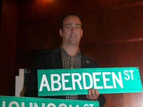 Kingston Mayor Mark Gerretsen holds up some decommissioned street signs at City Hall in Kingston on Thursday September 11 2014 that the city is offering in an on-line sale for charity.(IAN MACALPINE-KINGSTON WHIG-STANDARD/QMI AGENCY