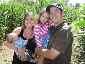 Jim and Sarah Wynn stand in their corn maze with their daughter Abigail and newborn son Thomas. Their maze is part of their farm on Highway 33, west of Bath. TUES., SEPT. 9,. 2014 KINGSTON, ONT. MICHAEL LEA\THE WHIG STANDARD\QMI AGENCY