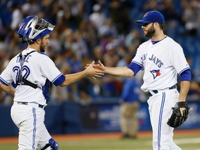 Toronto Blue Jays pitcher Brandon Morrow (right) shakes hands with  catcher Josh Thole after closing out the ninth inning against the Chicago Cubs at Rogers Centre on Sept. 10, 2014. Toronto defeated Chicago 11-1. (JOHN E. SOKOLOWSKI/USA TODAY Sports)