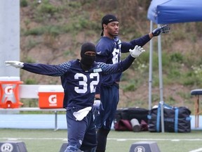Andre Durie (front) and Greg Childs stretching in the cold weather during the Argonauts' practice on Sept. 11. (Veronica Henri, Toronto Sun)