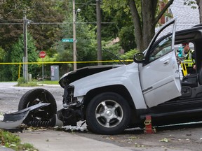 Belleville Police Const. Brad Stitt measures the scene on Dufferin Avenue north of Victoria Avenue in Belleville, Ont. after a northbound Chevrolet Trailblazer struck a tree Thursday, September 11, 2014. - Luke Hendry/The Intelligencer/QMI Agency