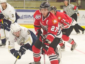 Saints rookie defenceman Graydon Smith takes to the air to knock the puck loose from Alec Jon Banville’s stick during the home opener for the Saints on Sept 6. The Saints went on to post a 5-4 win. - Gord Montgomery, Reporter/Examiner