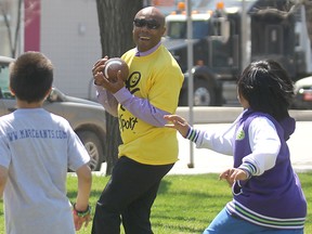 Former Winnipeg Blue Bomber Dave Donaldson catches a touchdown pass during a pickup game with some inner city students prior to a media event at the University of Winnipeg on Wed., May 22, 2013.