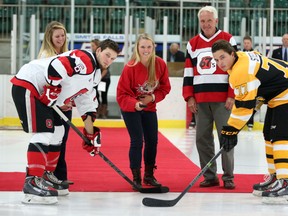 Brooke Henderson, now that top-ranked Canadian female amateur golfer, drops the opening face off between 67's Jonathan Duchesne and ​Kingston's Warren Steele as sister Brittany and Smiths Falls Mayor Dennis Staples look on Friday night. (Chris Hofley/Ottawa Sun)
