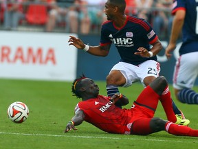 TFC’s Dominic Oduro loses the ball to New England’s Darrius Barnes. With eight games remaining, TFC needs a win tonight. (Dave Abel/Toronto Sun)