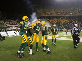 Edmonton quarterback Mike Reilly (13) celebrates his touchdown with fellow players against Montreal during the second half of a CFL football game between the Edmonton Eskimos and the Montreal Alouettes at Commonwealth Stadium in Edmonton, Alta., on Friday, Sept. 12, 2014. The Eskimos won 33-16. Ian Kucerak/Edmonton Sun/ QMI Agency