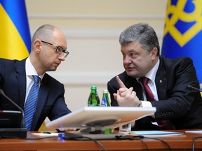 Ukrainian President Petro Poroshenko (R) talks with Prime Minister Arseny Yatseniuk during a government meeting in Kiev, Sept. 10, 2014. REUTERS/POOL