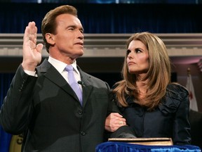 Arnold Schwarzenegger is joined by his wife Maria Shriver while being sworn into office for a second term by Supreme Court Chief Justice Ronald George (unseen) during his inauguration ceremony at the Memorial Auditorium in Sacramento, California in this Jan. 5, 2007 file photo.   REUTERS/Rich Pedroncelli/Pool/Files