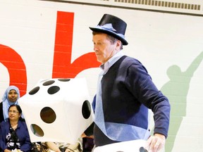 Mayoral Candidate John Tory rolls the dice during a giant Monopoly Game at Central Neighbourhood House on  Sept. 13, 2014. (Veronica Henri/Toronto Sun)