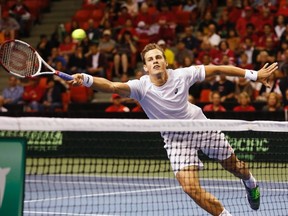 Vasek Pospisil of Canada dives for the ball during his Davis Cup world group men's doubles match with partner Daniel Nestor against Colombia's Juan-Sebastian Cabal and Robert Farah at the Metro Centre in Halifax on September 13, 2014. (REUTERS/Paul Darrow)