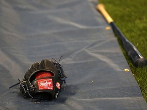 A baseball glove and bat of the Milwaukee Brewers during batting practice before the game against the Atlanta Braves at Miller Park on April 1, 2014. (Jeffrey Phelps/Getty Images/AFP)