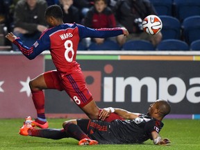 TFC’s Justin Morrow tries to tackle the Fire’s Grant Ward in Chicago last night. With the draw, the Reds stayed three points behind Philadelphia for the final playoff spot in the East. (USA Today Sports)