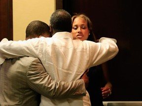 Running back Ray Rice of the Baltimore Ravens gets a hug from his wife Janay and father in law Joe Palmer following a news conference at the Ravens training center on May 23, 2014 in Owings Mills, Maryland. (Rob Carr/Getty Images/AFP)