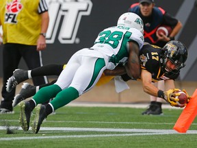 Ticats' Luke Tasker dives to get the ball over the goalline despite coverage from Roughriders' TRistan Jackson on Sunday at Tim Hortons Field. (Mark Blinch, Reuters)
