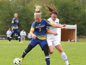 Laurentian Voyageurs Megan Ferguson fights for position while kicking the ball  during OUA action against the Carleton Ravens on Sunday afternoon.