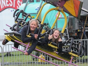 Abbie Matheson, left, and Kayla Hartwick take a ride on the Hang Glider in the rain. The wet weather didn't stop people from taking in the Kingston Fall Fair on Saturday. (Julia McKay/The Whig-Standard)