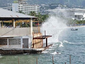 Waves pound the beach in Acapulco as Hurricane Odile churns far off shore September 14, 2014.   REUTERS/Claudio Vargas