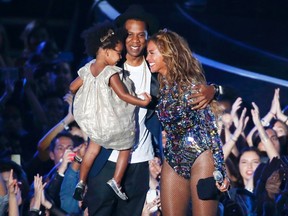 Beyonce smiles with Jay Z and daughter Blue Ivy after accepting the Video Vanguard Award on stage during the 2014 MTV Video Music Awards in Inglewood, Calif., on August 24, 2014. (REUTERS/Lucy Nicholson)