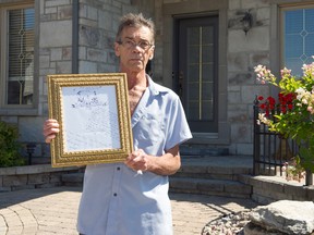 Michel Beaudry poses with a letter from his wife in front of his house in Quebec. (PATRICE BERNIER/QMI Agency)