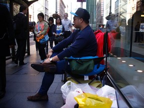 Christian Ibrahim sits outside an Apple store in central Sydney September 10, 2014. (REUTERS/David Gray)