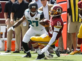 Washington Redskins quarterback Robert Griffin III (10) runs with the ball as Jacksonville Jaguars cornerback Dwayne Gratz (27) defends in the first quarter at FedEx Field. (Geoff Burke-USA TODAY Sports)