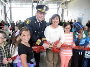 Mayor Joni Baechler and London Fire Chief John Kobarda get some help connecting the ceremonial hose from a group of students Friday, September 12. GERARD CRECES\SPECIAL TO LONDONER