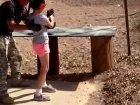 Shooting instructor Charles Vacca stands next to a 9-year-old girl at the Last Stop shooting range in White Hills, Arizona near the Nevada border, on August 25, 2014. (REUTERS/Mohave County Sheriff's Office)