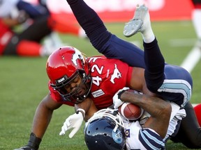 Stampeders’ Deron Mayo decks Argonauts’ Trent Guy in Calgary on Saturday. After blowing a huge second-half lead, the Argos need to regroup against the Lions on Friday night. (Darren Makowichuk/Qmi Agency)