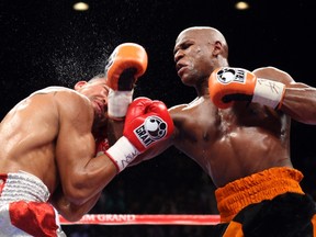WBC welterweight champion Victor Ortiz (left) of the U.S. takes a punch from Floyd Mayweather Jr., also of the U.S., during their title fight at the MGM Grand Garden Arena in Las Vegas on September 17, 2011. (REUTERS/Steve Marcus)