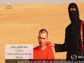 A video purportedly showing threats being made to a man Islamic State named as  David Haines by a masked ISIS fighter in an unknown location in this still image from video released by Islamic State Sept. 2. Haines was later beheaded.
