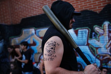 A man with a tattoo that reads, "God gave you life, I take it from you", is seen before taking part in the "Survival Zombie" competition in Collado Villalba, outside Madrid, September 6, 2014. According to the back-story of the "Survival Zombie" contest, participants, who signed up as survivors, are trapped for a night in a city that has been infected with a virus that causes humans to turn into zombies. The objective of the game is for the survivors to stay alive until morning by avoiding getting touched by a zombie. In order to do so, the contestants need to find clues that will help them reach a safe haven, the end point of the contest. Survivors are not allowed to attack the zombies, a role made up of other players as well as members of the contest organization, so their only means of survival is by avoiding them. A single touch of a zombie eliminates the player, but they can return as zombies after getting made up, so that they can continue playing. A group of actors dressed as soldiers are also involved in the game, helping some players against the zombies or making it harder for others to solve the clues to survive. Picture taken September 6, 2014. REUTERS/Susana Vera