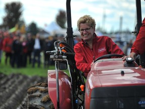 Ontario Premier Kathleen Wynne tries her hand at plowing during the opening day of the International Plowing Match and Rural Expo near Barrie Tuesday, Sept. 16, 2014. (MARK WANZEL PHOTO)