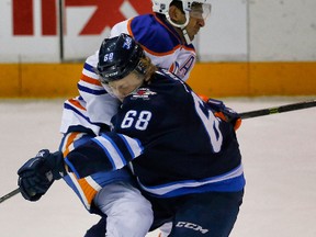 Oilers centre Jujhar Khaira collides with Ryan Olsen of the Winnipeg Jets during the 2014 Young Stars Classic Tournament in Penticton, B.C. on Monday. (Al Charest, QMI Agency)