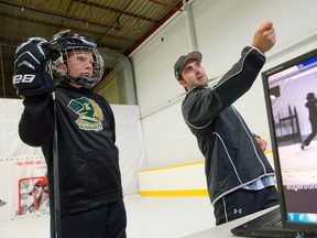 Nick Smith talks with hockey player Quinton Pepper as they analyze his shot using a high speed camera at Base Hockey in London. (CRAIG GLOVER/The London Free Press)