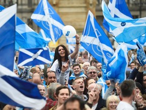Campaigners wave Scottish Saltires at a 'Yes' campaign rally in Glasgow, Scotland September 17, 2014. REUTERS/Dylan Martinez