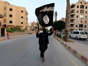 A member loyal to the Islamic State waves his organization's flag in a Syrian town.