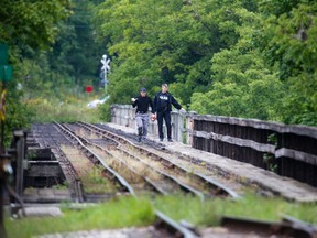 Police walk across railway trestle bridge in St. Thomas, Ontario on Monday, September 15, 2014. (DEREK RUTTAN, The London Free Press)