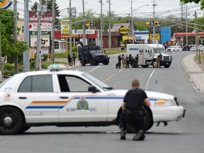 Police surround a house during the search for Justin Bourque in Moncton, N.B., in this June 5, 2014 file photo. (MAXIME DELAND/Postmedia Network)