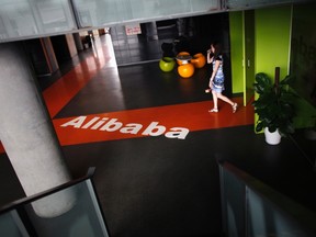An employee walks past a logo of Alibaba (China) Technology Co. Ltd during a media tour organized by government officials at its headquarters on the outskirts of Hangzhou, Zhejiang province June 20, 2012. REUTERS/Carlos Barria