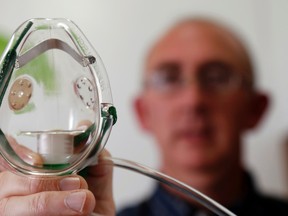 Pediatrician Dr. Paul Dempsey holds an oxygen mask in his practice in Belleville, Ont. Wednesday, September 17, 2014. He said parents need not be concerned about enterovirus D68 unless a child's symptoms become severe. Luke Hendry/The Intelligencer/QMI Agency