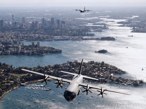 Two Royal Australian Air Force (RAAF) C-130J Hercules aircraft fly above the Sydney Opera House and Sydney Harbour Bridge during a display, in this handout picture released by the Australian Defence Force September 10, 2014. (REUTERS/Australian Defence Force/Handout via Reuters)