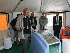 Dr. Michael Shannon, left, explains how the Medizone's AsepticSure Hospital Disinfection System sterilizes a room, to a group of 20 medical, military and media representatives, in the Design Shelter Inc temporary structure behind Innovation Park on Thursday September 18, 2014. JULIA MCKAY/Kingston Whig-Standard/QMI Agency