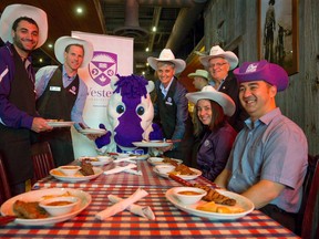 Western University Student Council president Matt Helfand, left, provost Janice Deakin and 2014 Homecoming chair Mark Millar serve up plates of steak and eggs to Western Mustangs mascot J.W. as Western Alumni Relations executive director Trista Walker, Alumni Association president John Eberhard and Alumni Relations development officer Kenji Saito join them in kicking off Homecoming weekend at Lone Star Texas Grill on Richmond Street in London, Ontario on Thursday September 18, 2014.
CRAIG GLOVER/The London Free Press/QMI Agency