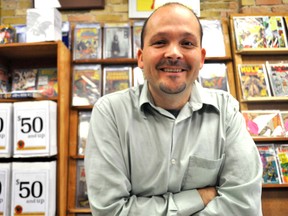 Andrew Greenham, owner of Forest City Coins and Stamps, stands in front of a wall of comic books in the store September 17, 2014. Greenham is the third member of his family to run the store, which celebrates its 50th anniversary October 18-25. CHRIS MONTANINI\LONDONER\QMI AGENCY