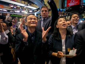 Alibaba Group Holding Ltd founder Jack Ma (front C) and chief financial officer Maggie Wu react (front R) as the company's initial public offering (IPO), under the ticker "BABA", begins trading at the New York Stock Exchange in New York Sept. 19, 2014. REUTERS/Brendan McDermid