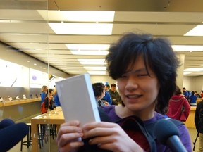 Akira Xu mugs with the new iPhone 6 he was first in line to get at the Apple Store at the Rideau Centre – after waiting 21 hours. (MEGAN GILLIS/OTTAWA SUN)